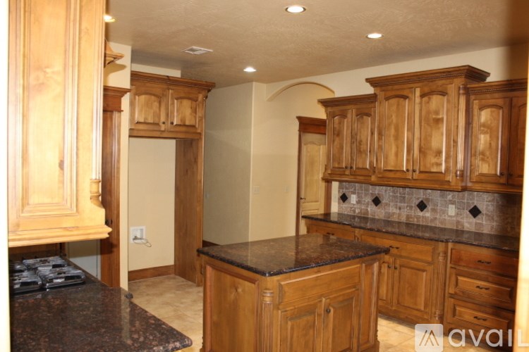 A kitchen with wooden cabinets and a granite countertop.