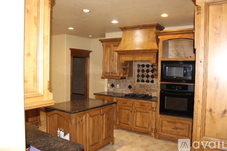 A kitchen with wooden cabinets and black countertops.