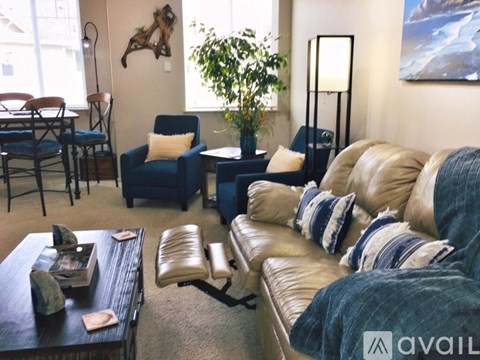 A living room with a blue couch and a wooden coffee table.