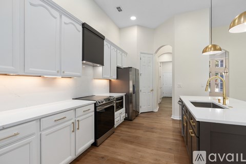 A kitchen with white cabinets and a black stove top oven.