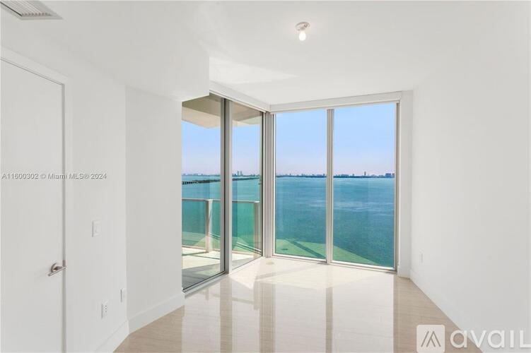 A spacious room with a view of the water through large windows.