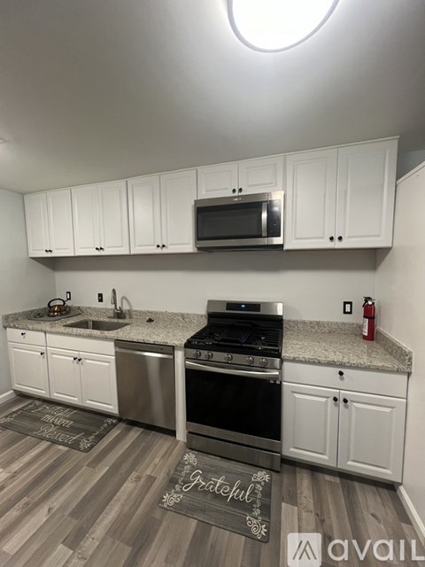 A kitchen with white cabinets and a stainless steel oven.