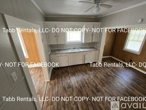 A room with wooden floors and a ceiling fan is shown with a disclaimer from Tabb Rentals, LLC.
