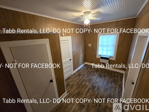 A room with wooden walls and a ceiling fan is shown with a disclaimer from Tabb Rentals, LLC.
