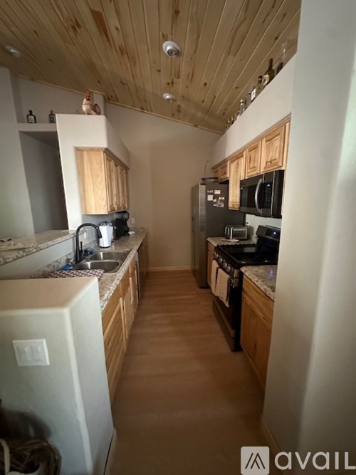 A kitchen with wooden cabinets and a white fridge.