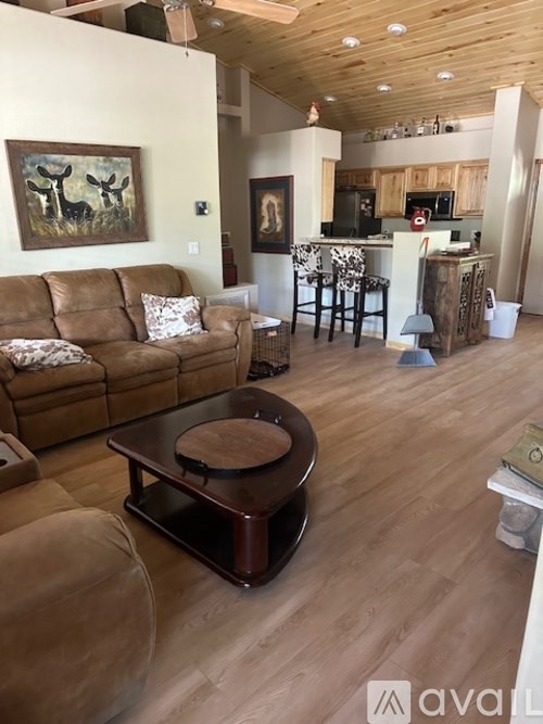 A living room with a brown couch and a coffee table.