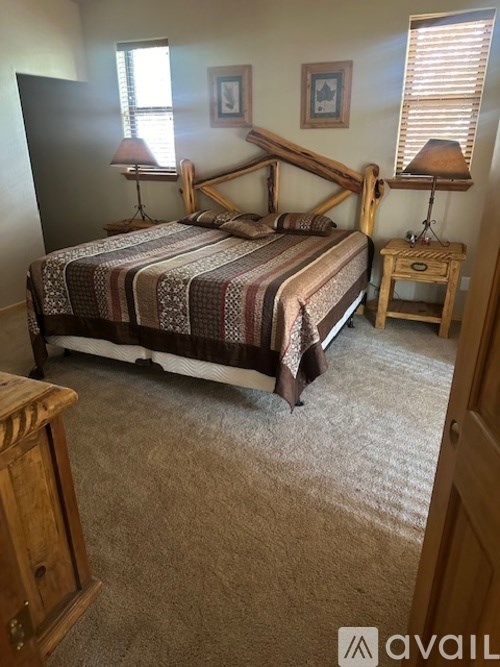 A bedroom with a bed, nightstand, and lamp.