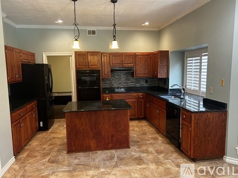 A kitchen with wooden cabinets and black appliances.