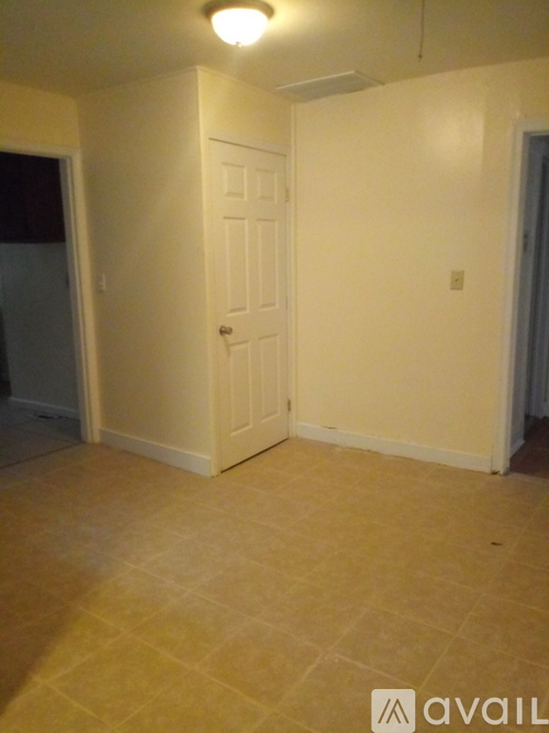 A room with a white door and a tiled floor.