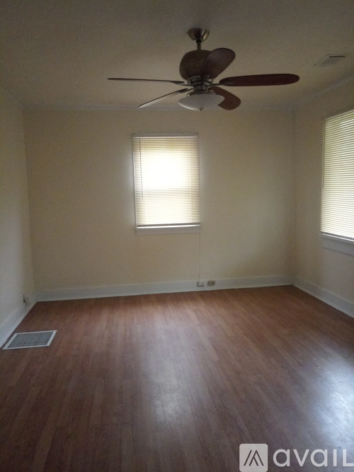 A room with a ceiling fan and a window with blinds.