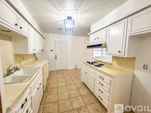 A kitchen with white cabinets and a beige countertop.