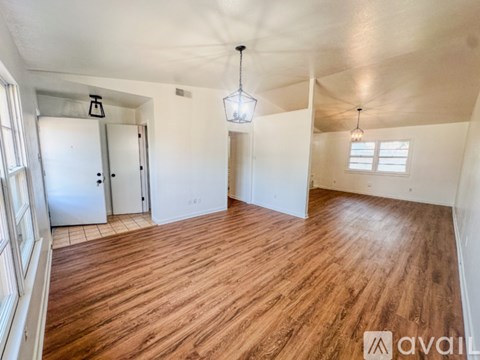 A room with wooden flooring and white walls.