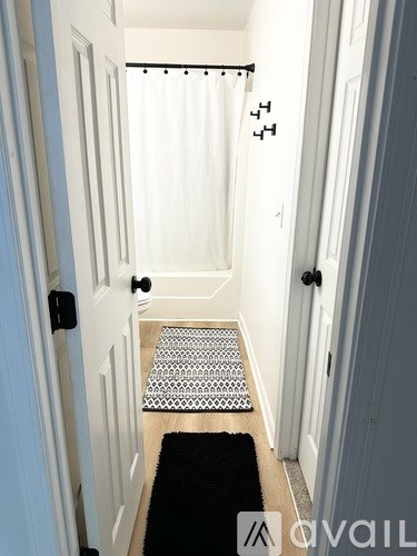 A hallway with a black and white patterned rug.
