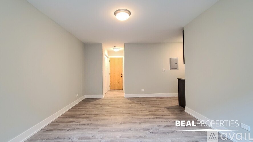 A spacious empty room with a door and a light on the ceiling.