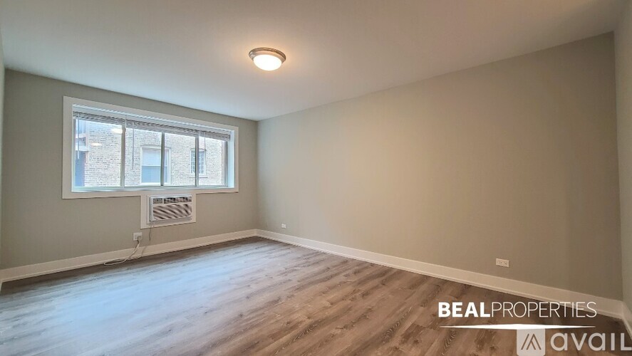 A room with a window and wooden flooring is available for rent.
