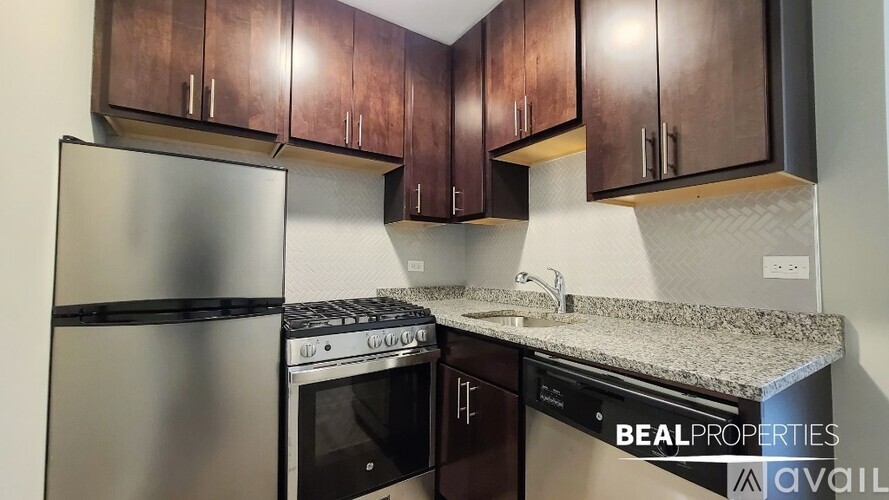 A kitchen with a stainless steel refrigerator, a stove, and a dishwasher.