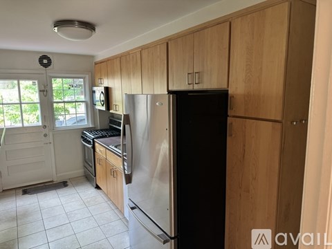 A kitchen with wooden cabinets and a black fridge.