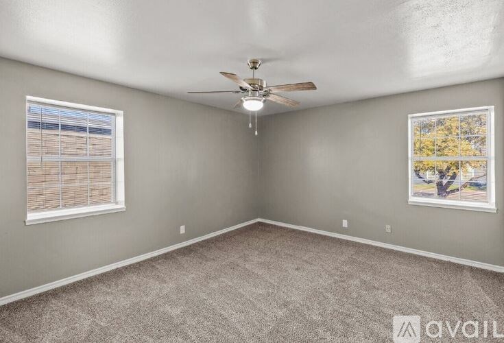 A room with a ceiling fan and a window with blinds.