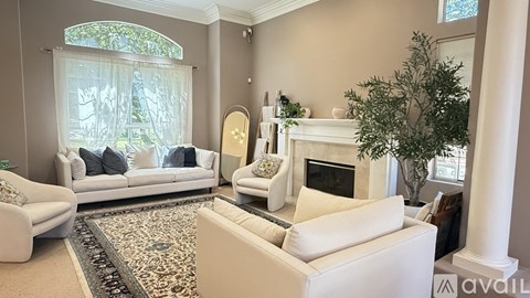 A living room with a white couch and a fireplace.