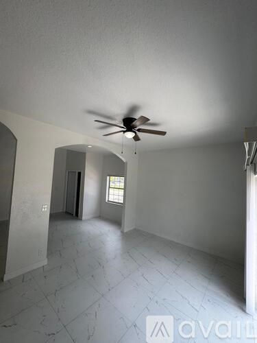 A room with a ceiling fan and a window.