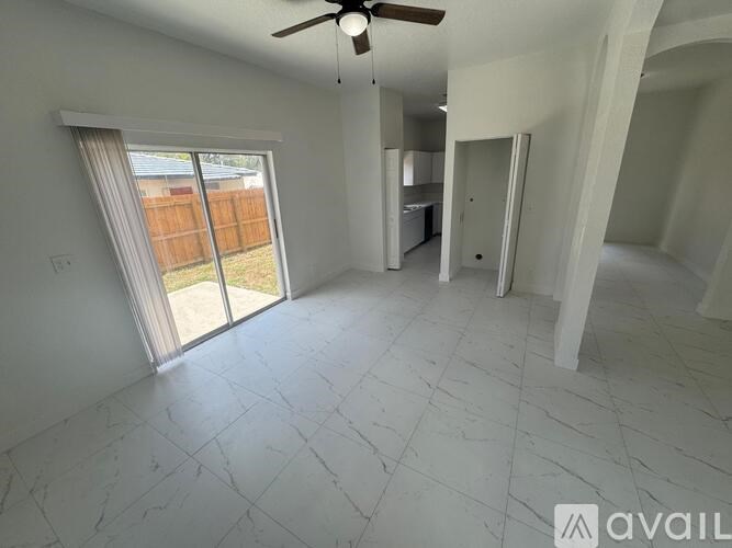 A spacious living room with a sliding glass door leading to a backyard.