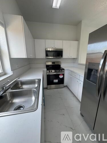 A kitchen with white cabinets and stainless steel appliances.