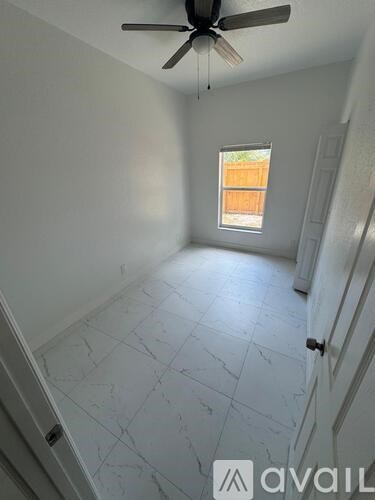 A room with a ceiling fan and a window.