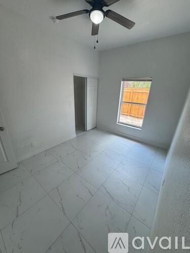 A room with a ceiling fan and a window.