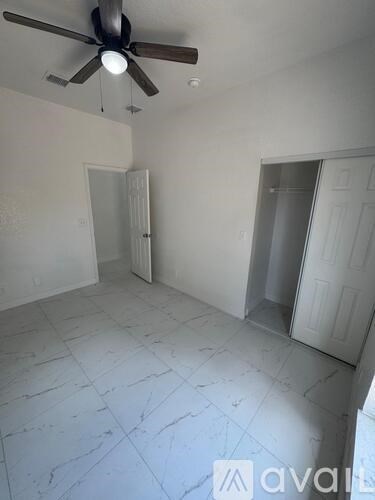 A room with a ceiling fan and two doors.