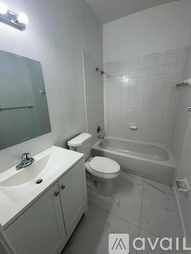 A bathroom with a toilet, sink, and bathtub.