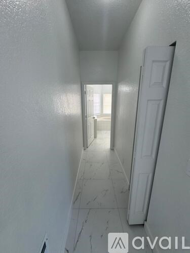 A hallway with a white door on the right.