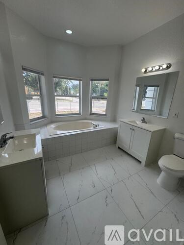 A bathroom with a tub, toilet, and sink.