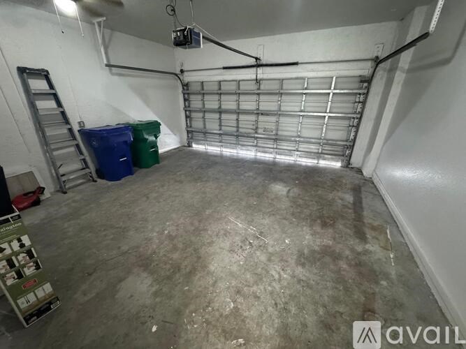 A room with a metal grate on the floor and a ladder on the left side.