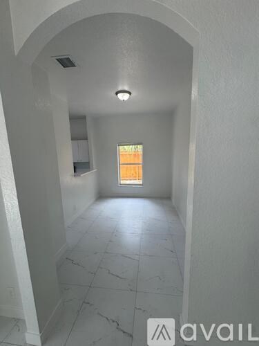 A hallway with a light on and a window at the end.