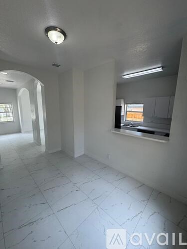 A white room with a window and a mirror on the wall.