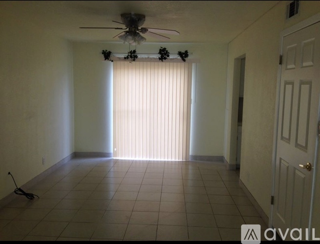 A room with a ceiling fan and a door.