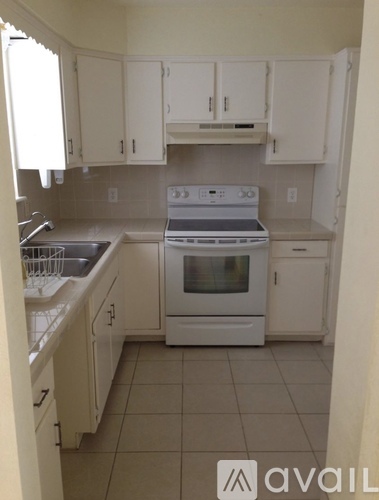 A kitchen with white cabinets and appliances.