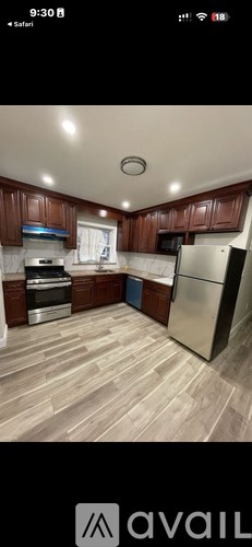 A kitchen with wooden cabinets and a refrigerator.