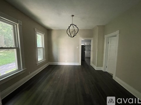 A room with wooden floors and a chandelier hanging from the ceiling.