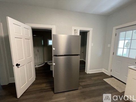 A kitchen with a stainless steel refrigerator and white doors.