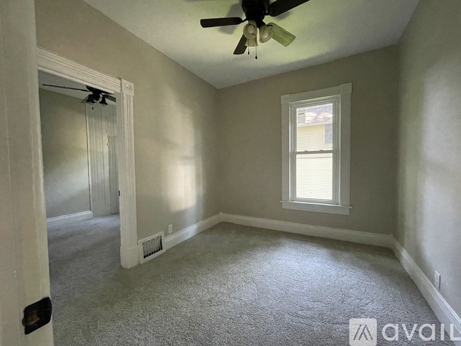 A room with a ceiling fan and a window.