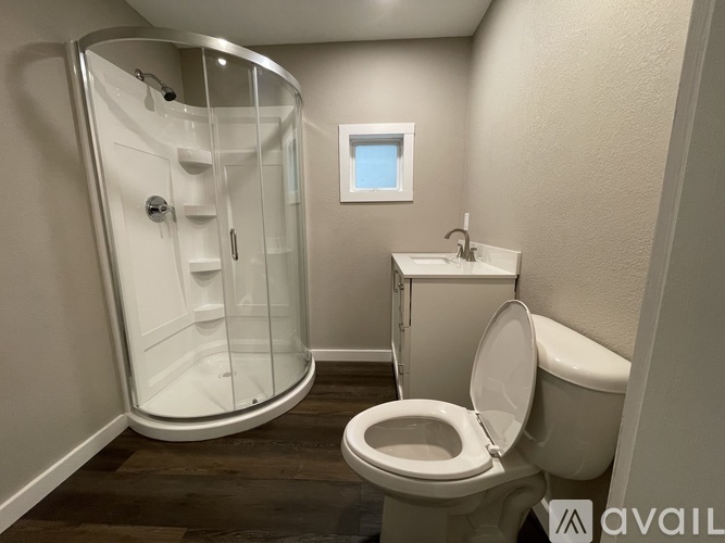 A bathroom with a toilet, sink, and shower.