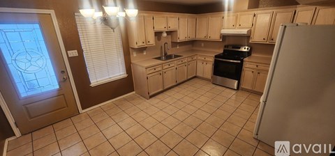 A kitchen with a refrigerator on the right side.