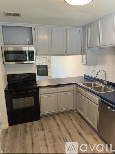 A kitchen with a black oven and white cabinets.