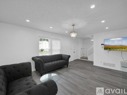A living room with a black sofa and a glass coffee table.
