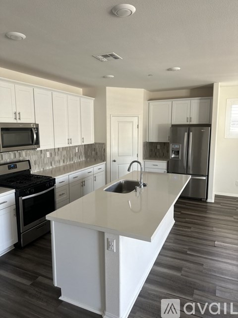 A kitchen with white cabinets and a central island.