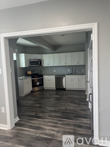 A kitchen with white cabinets and a microwave.