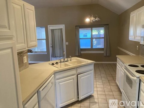 A kitchen with white cabinets and appliances.