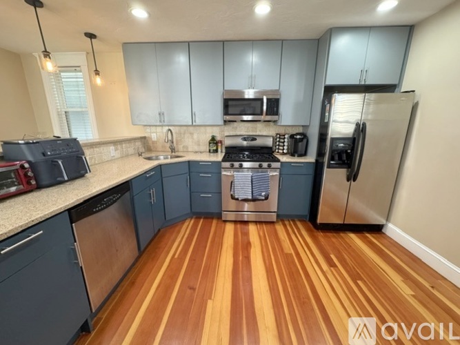A kitchen with wooden floors and modern appliances.