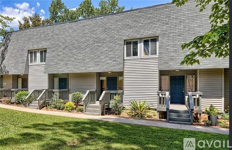 A grey house with a blue door and windows.
